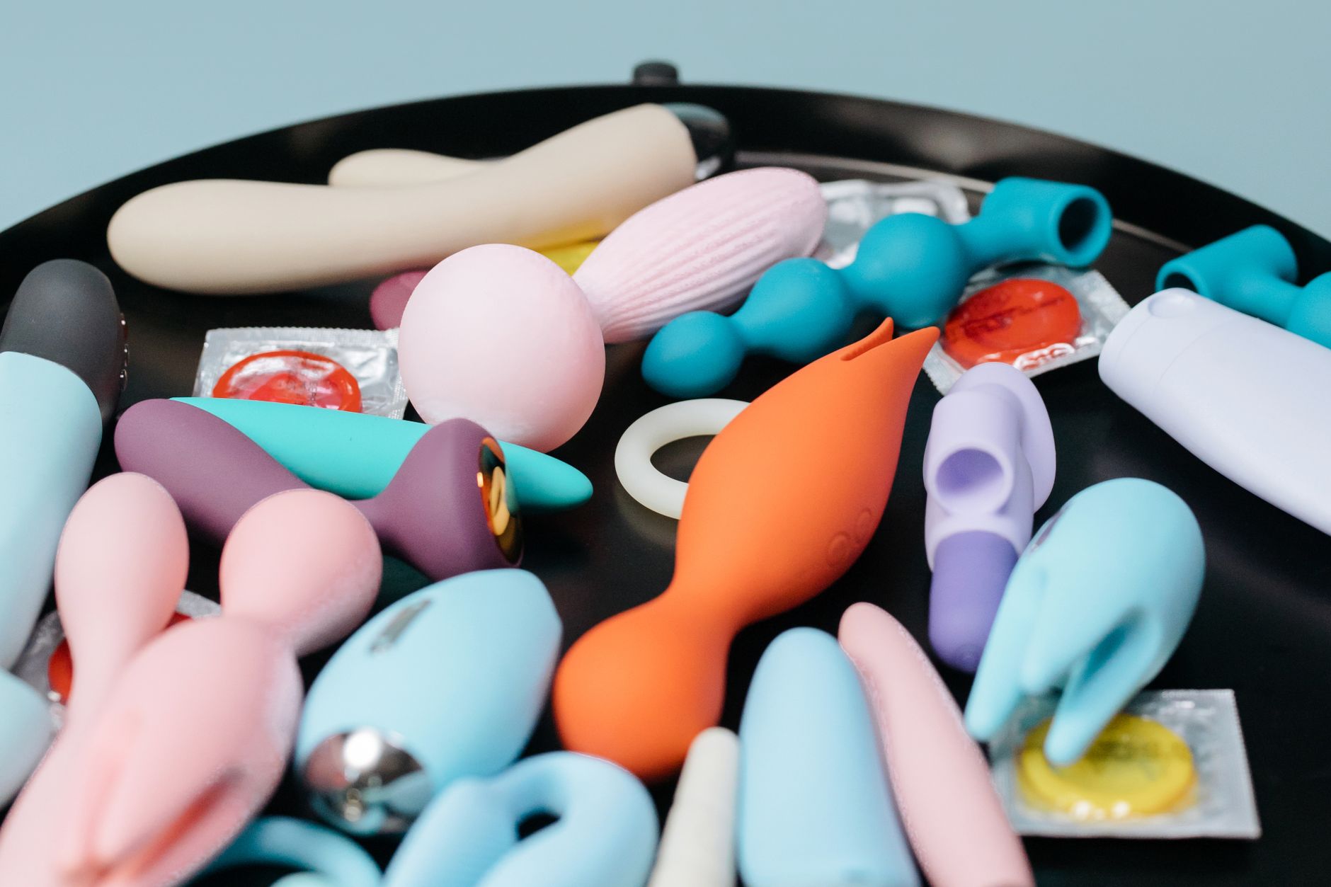 A vibrant collection of lemon and other clitoral vibrators displayed on a black tray